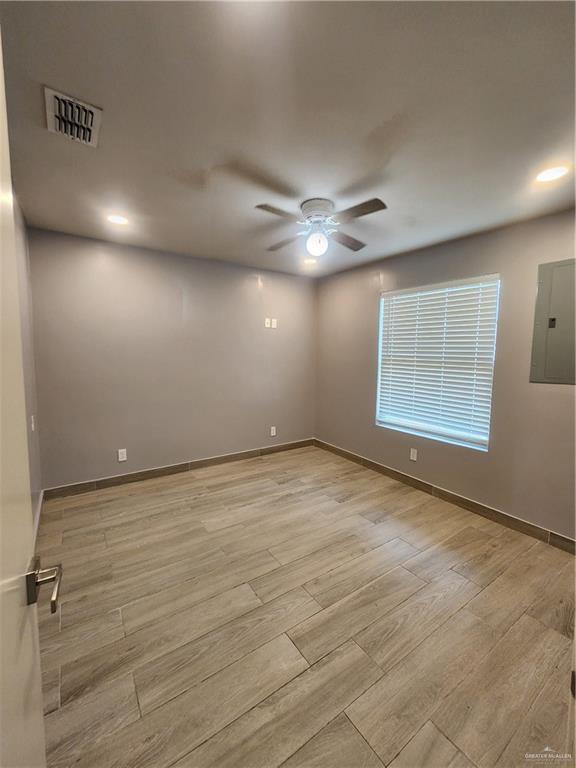 607 N Padre Ave, Weslaco, TX 78596 - unfurnished room featuring a ceiling fan, electric panel, wood finished floors, and recessed lighting