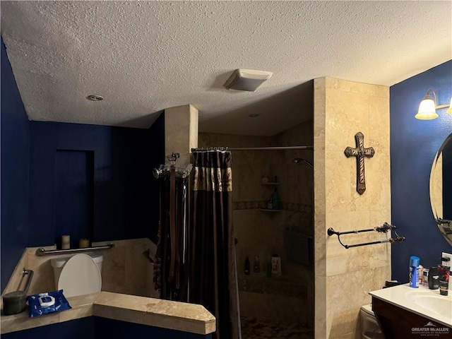 bathroom with vanity, a textured ceiling, toilet, and curtained shower