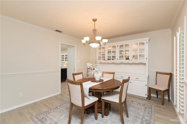 2009 E 29th St, Mission, TX 78574 - dining room with a chandelier, light wood-style floors, crown molding, and baseboards