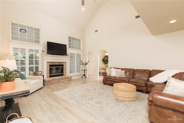 2009 E 29th St, Mission, TX 78574 - living room featuring high vaulted ceiling, arched walkways, wood finished floors, a brick fireplace, and recessed lighting