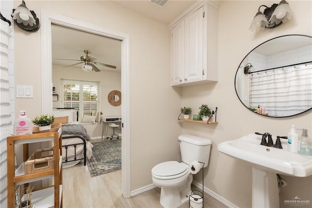 2009 E 29th St, Mission, TX 78574 - bathroom featuring ceiling fan, toilet, wood finished floors, baseboards, and a shower with shower curtain