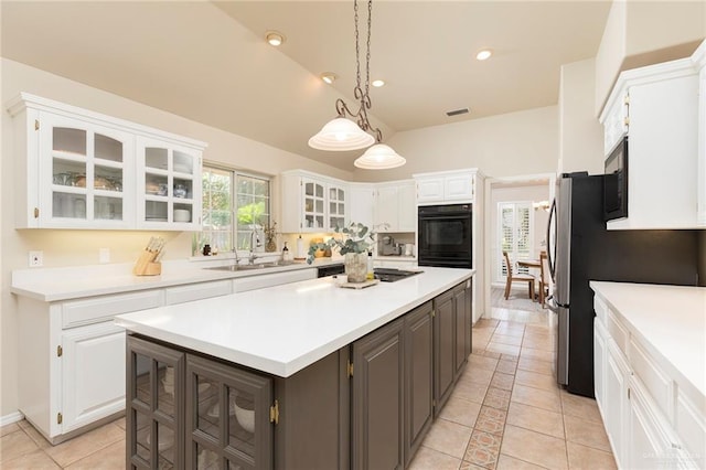 2009 E 29th St, Mission, TX 78574 - kitchen with a sink, white cabinetry, a kitchen island, light countertops, and glass insert cabinets