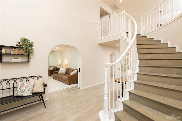 2009 E 29th St, Mission, TX 78574 - staircase featuring arched walkways, wood finished floors, baseboards, and a high ceiling