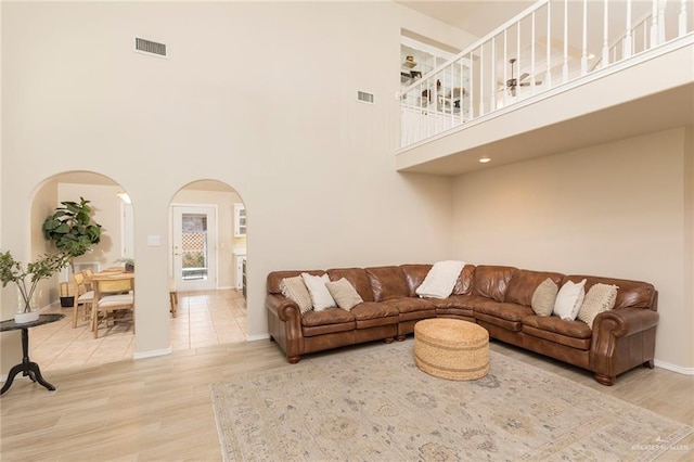 2009 E 29th St, Mission, TX 78574 - living room with arched walkways, a high ceiling, wood finished floors, and baseboards