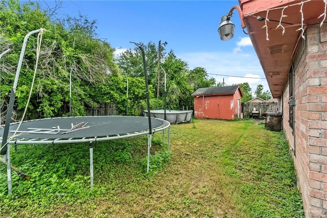 view of yard featuring a storage unit and a trampoline