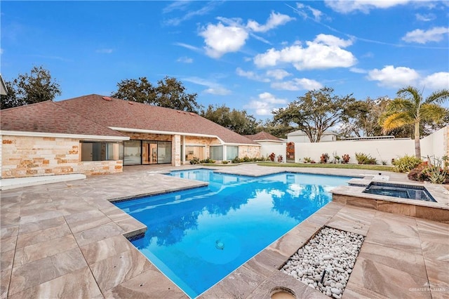 view of swimming pool featuring a patio area and an in ground hot tub