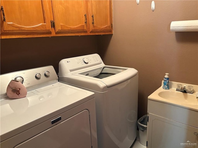 laundry area featuring cabinets, sink, and washer and dryer