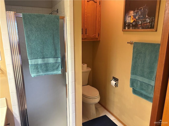 bathroom featuring toilet, tile patterned flooring, and a shower with door