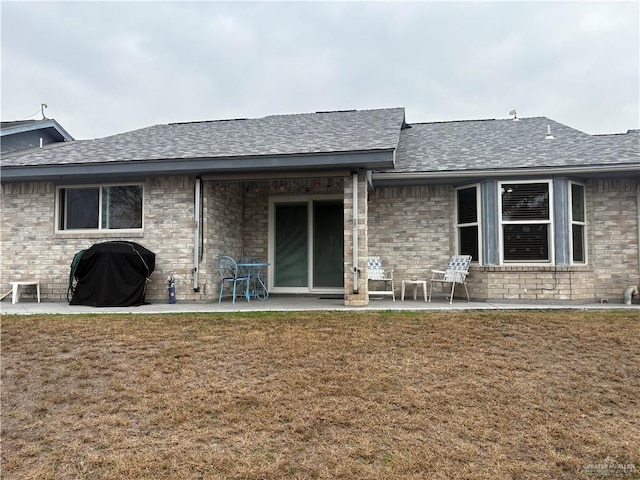 rear view of property featuring a patio area and a lawn