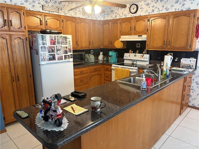 kitchen featuring sink, white appliances, kitchen peninsula, and light tile patterned floors