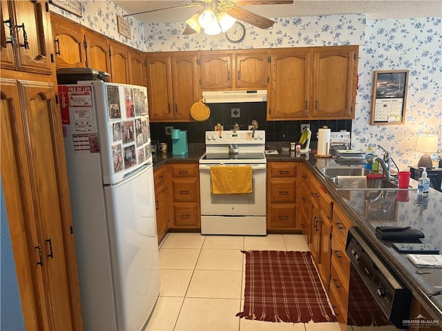 kitchen with sink, light tile patterned floors, white appliances, ceiling fan, and a textured ceiling