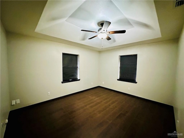 spare room featuring hardwood / wood-style floors, a raised ceiling, and ceiling fan