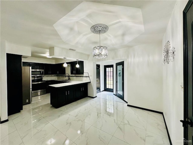 kitchen with appliances with stainless steel finishes, pendant lighting, sink, a chandelier, and a center island