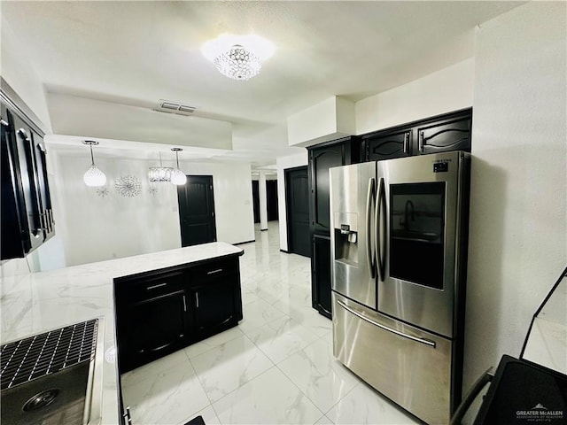 kitchen with stainless steel fridge with ice dispenser and hanging light fixtures