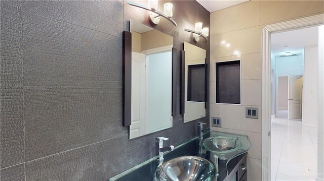 bathroom with tile walls, sink, and tile patterned floors