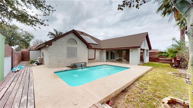 view of pool with pool water feature and a lawn