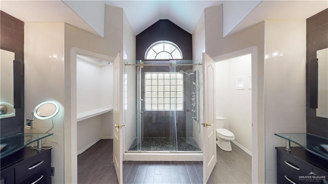 bathroom with vanity, vaulted ceiling, toilet, and walk in shower