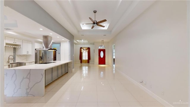 interior space with sink, a tray ceiling, and ceiling fan