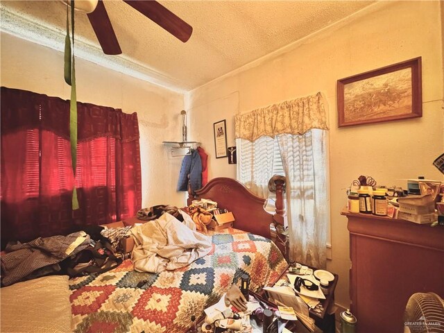 bedroom with ceiling fan and a textured ceiling