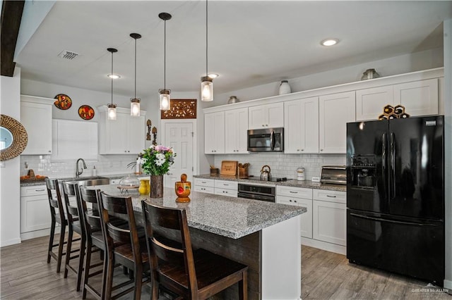 35206 Longhorn Dr, Linn, TX 78563 - kitchen featuring black appliances, light wood-style floors, decorative backsplash, and recessed lighting