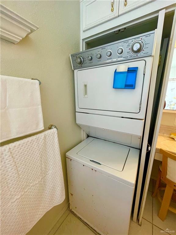 washroom featuring light tile patterned floors and stacked washer / drying machine