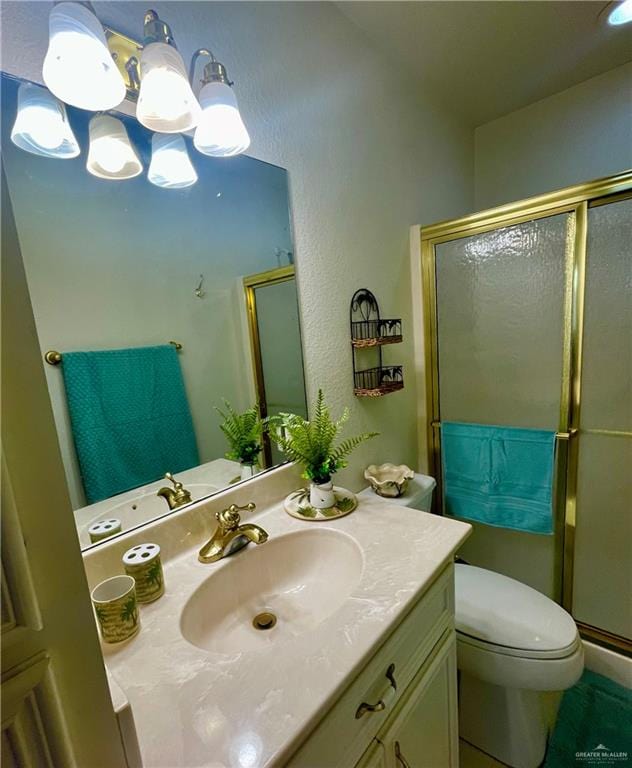 bathroom with vanity, an enclosed shower, and toilet