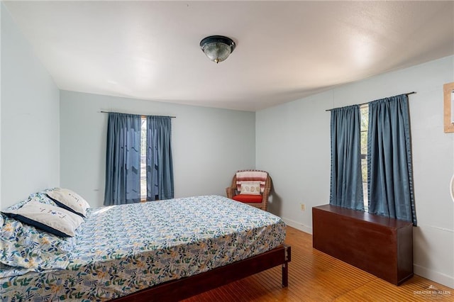 bedroom featuring wood finished floors and baseboards