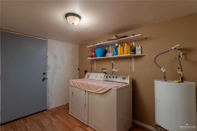 washroom featuring laundry area, light wood-style flooring, washer and dryer, and gas water heater