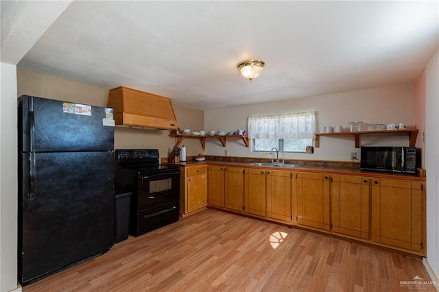 kitchen with dark countertops, light wood-type flooring, black appliances, open shelves, and a sink