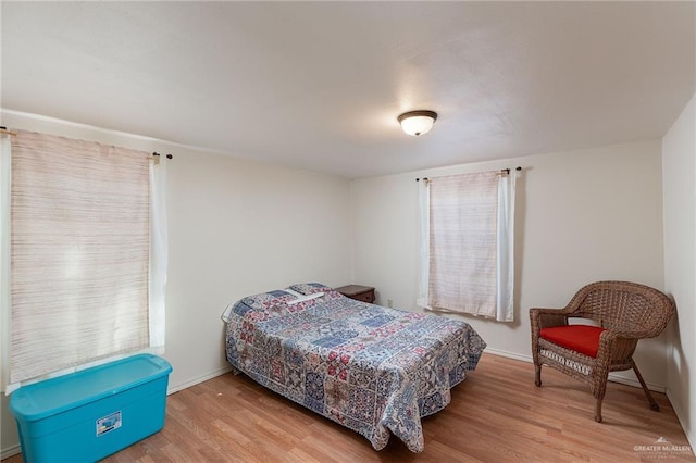 bedroom with wood finished floors and baseboards