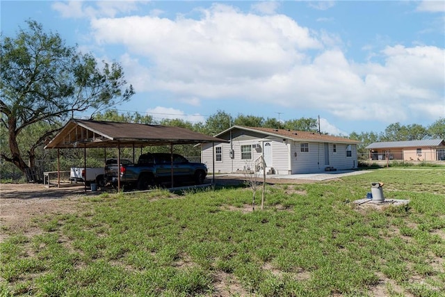 exterior space with a carport and a yard