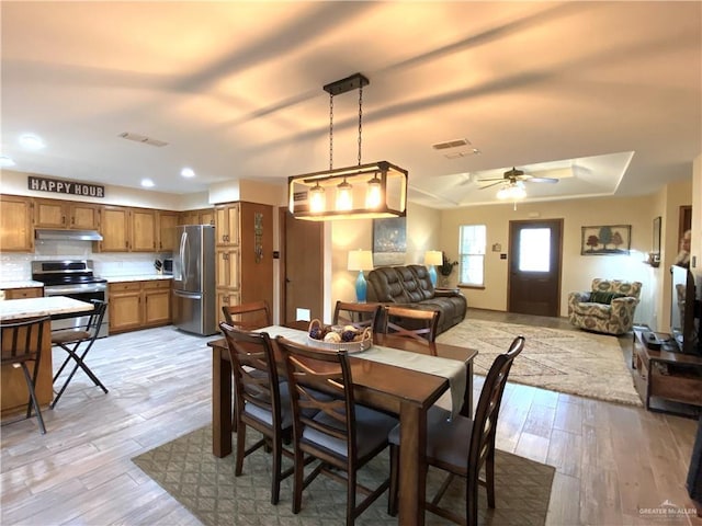 dining room with ceiling fan and light wood-type flooring