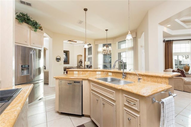 kitchen with appliances with stainless steel finishes, ceiling fan with notable chandelier, sink, light tile patterned floors, and pendant lighting