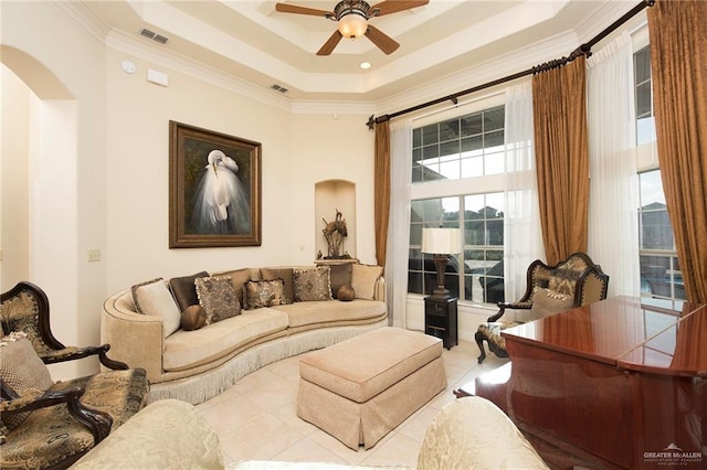 living room with light tile patterned floors, a raised ceiling, ceiling fan, and ornamental molding