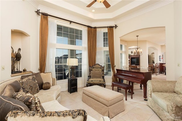 tiled living room featuring ceiling fan with notable chandelier and ornamental molding