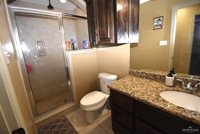 full bath featuring tile patterned flooring, a shower stall, vanity, and toilet