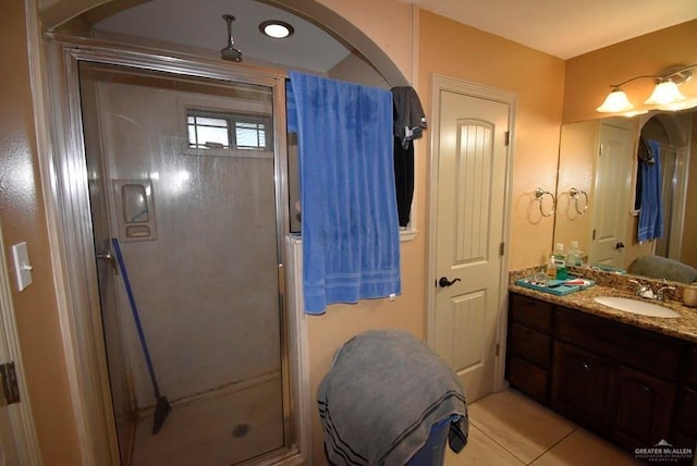 full bathroom featuring a stall shower, vanity, and tile patterned flooring