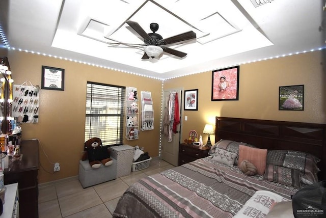 bedroom featuring light tile patterned flooring, baseboards, and a tray ceiling