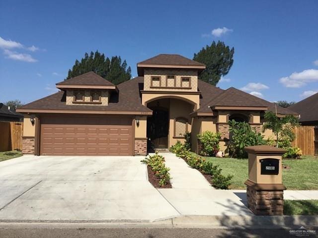 prairie-style house featuring concrete driveway, a garage, and fence