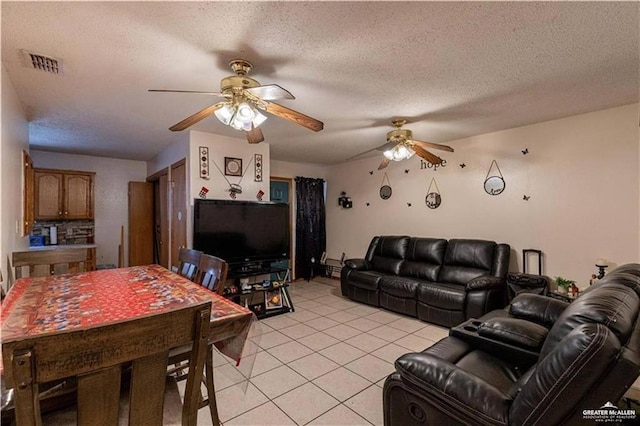 living room featuring ceiling fan, a textured ceiling, and light tile patterned floors