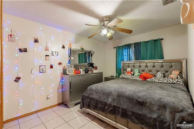 bedroom featuring ceiling fan, a textured ceiling, and light tile patterned floors