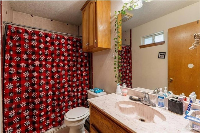 bathroom with toilet, a textured ceiling, tile patterned flooring, and vanity