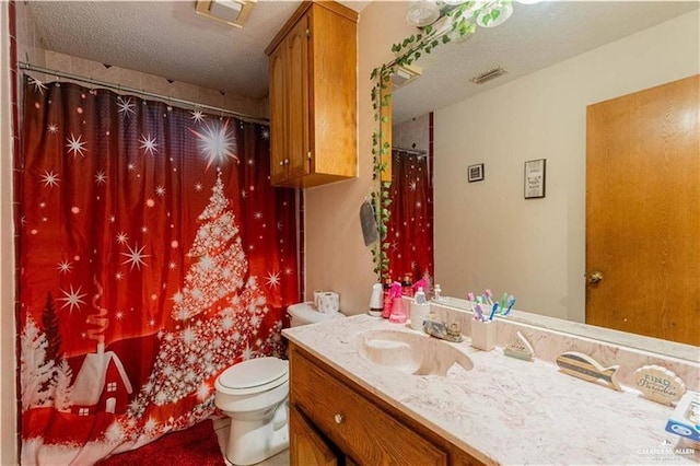 bathroom featuring vanity, toilet, and a textured ceiling