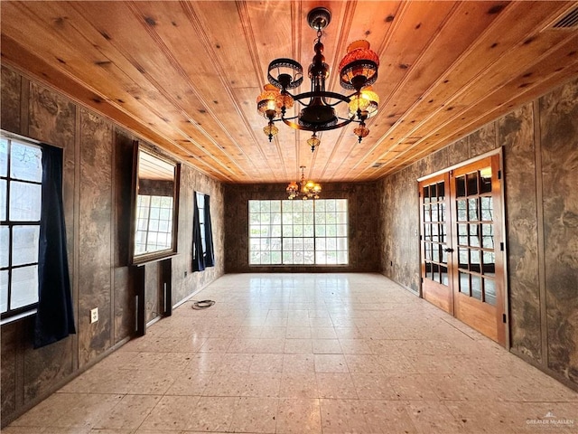 spare room with wood ceiling, french doors, and a chandelier