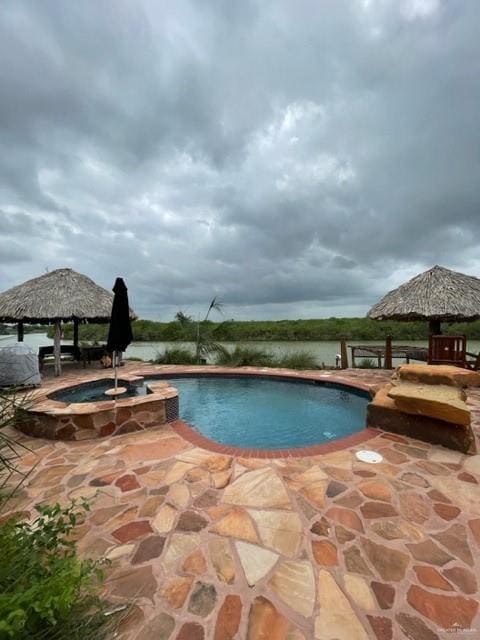 view of pool featuring an in ground hot tub, a gazebo, and a patio area