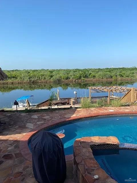 view of swimming pool with a water view and grilling area