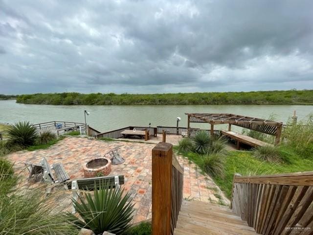 view of dock with a patio area, a water view, and a fire pit