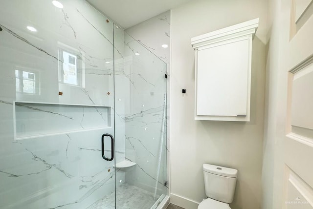 bathroom with toilet and a shower with shower door