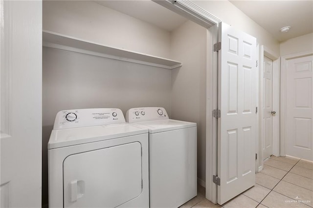 laundry room with washing machine and dryer and light tile patterned floors