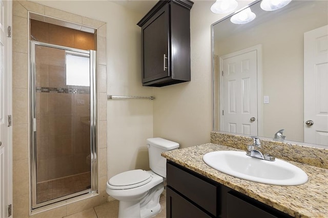 bathroom with tile patterned floors, vanity, toilet, and a shower with shower door